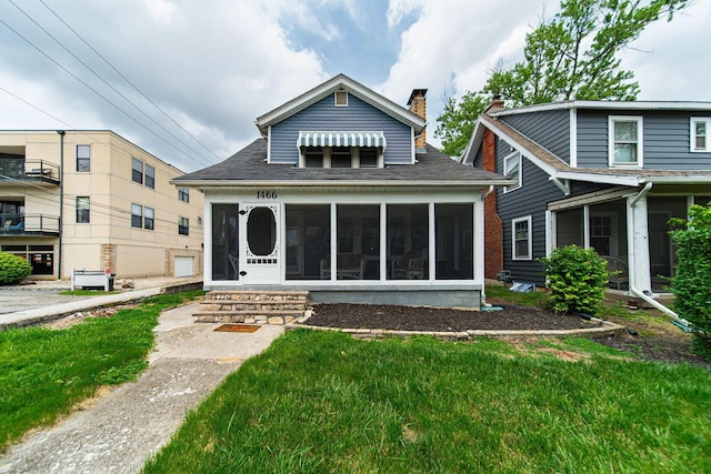1466 W 1st Ave, Columbus, OH 43212 - rear view of house with a sunroom, a chimney, a shingled roof, and a yard