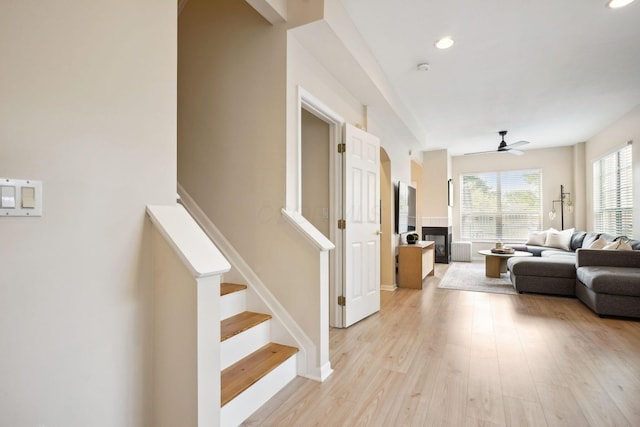 5535 Village Xing, Hilliard, OH 43026 - living area featuring a ceiling fan, stairway, light wood-type flooring, a glass covered fireplace, and recessed lighting