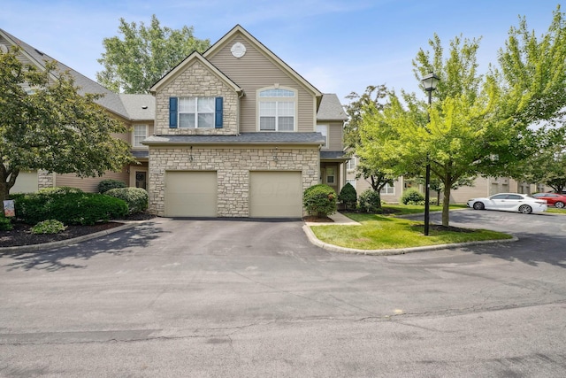 5535 Village Xing, Hilliard, OH 43026 - townhome / multi-family property with stone siding, driveway, and a garage