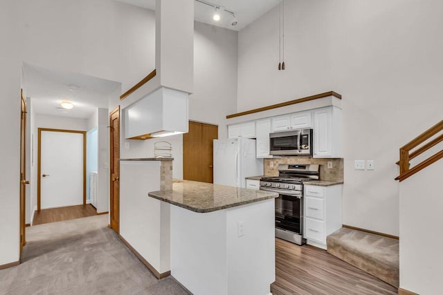 978 Kingsbury Ct, Newark, OH 43055 - kitchen with stainless steel appliances, a high ceiling, rail lighting, dark stone countertops, and white cabinetry