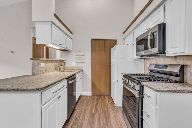 978 Kingsbury Ct, Newark, OH 43055 - kitchen featuring stainless steel appliances, light wood-style floors, backsplash, and white cabinetry