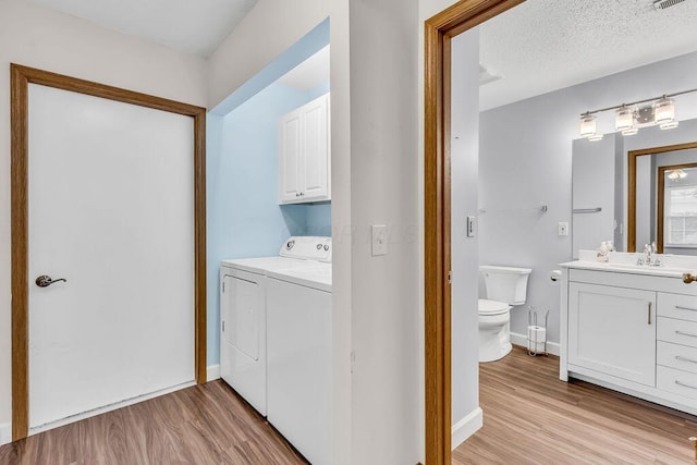 978 Kingsbury Ct, Newark, OH 43055 - laundry room with light wood-style floors, washer and dryer, and cabinet space