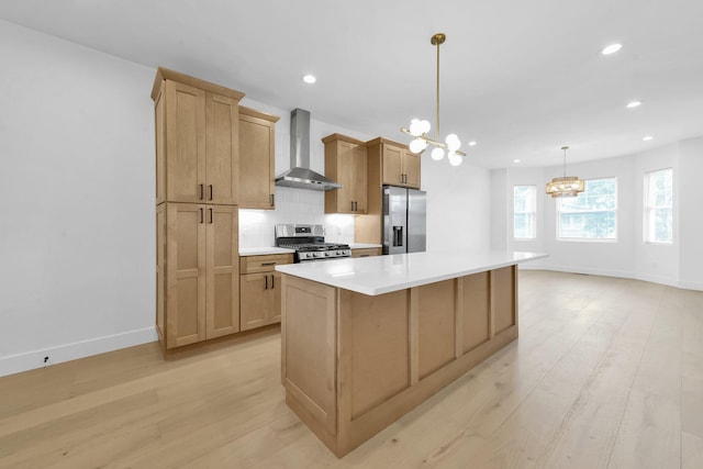 376 E Markison Ave, Columbus, OH 43207 - kitchen with wall chimney range hood, appliances with stainless steel finishes, a chandelier, light wood finished floors, and recessed lighting