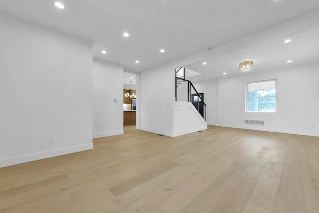 376 E Markison Ave, Columbus, OH 43207 - unfurnished living room featuring stairs, light wood-style flooring, and recessed lighting