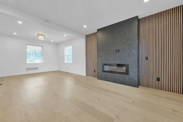 376 E Markison Ave, Columbus, OH 43207 - unfurnished living room featuring a tile fireplace, recessed lighting, and wood finished floors