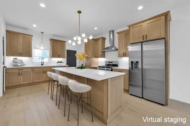 376 E Markison Ave, Columbus, OH 43207 - kitchen with wall chimney exhaust hood, appliances with stainless steel finishes, light wood-style flooring, backsplash, and a kitchen island