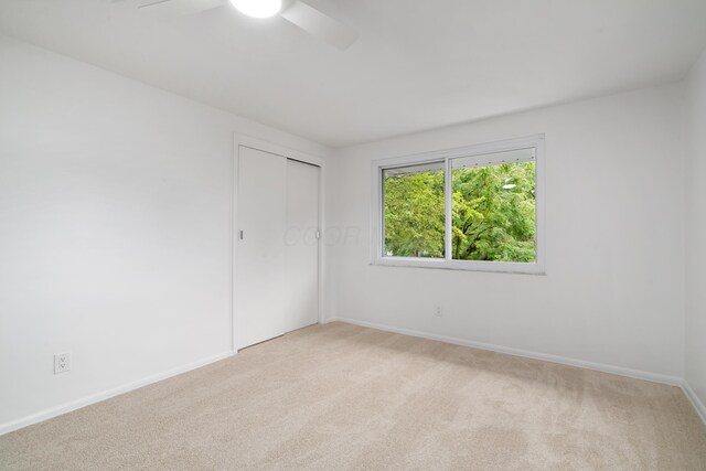 75 S Gould Rd, Columbus, OH 43209 - unfurnished bedroom with light colored carpet, a closet, and a ceiling fan