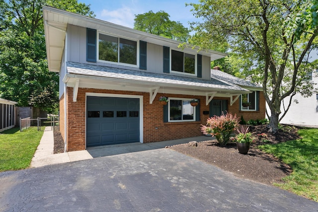 75 S Gould Rd, Columbus, OH 43209 - view of front of property with asphalt driveway, an attached garage, brick siding, and board and batten siding