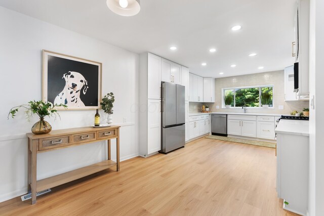 75 S Gould Rd, Columbus, OH 43209 - kitchen with appliances with stainless steel finishes, light countertops, recessed lighting, light wood-type flooring, and white cabinetry