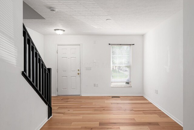 6290 Downwing Ln, Columbus, OH 43230 - entryway featuring light wood-style flooring and a textured ceiling