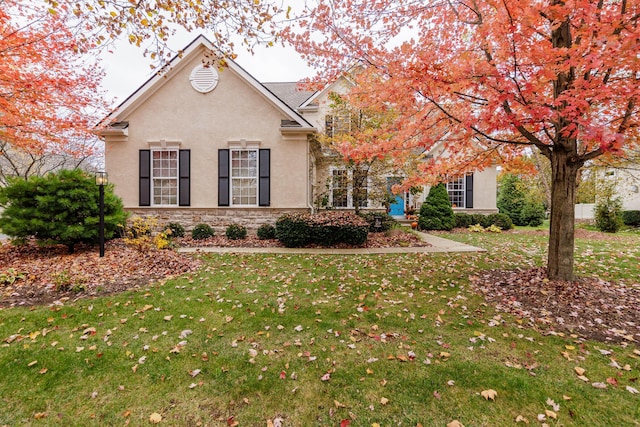 5893 Dunheath Loop, Dublin, OH 43016 - view of front of home with stucco siding, a front yard, and stone siding