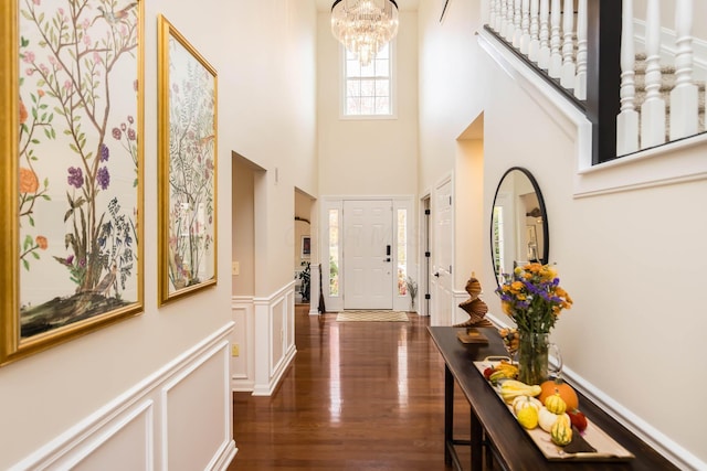 5893 Dunheath Loop, Dublin, OH 43016 - entryway featuring dark wood-type flooring, a high ceiling, a chandelier, a decorative wall, and a wainscoted wall