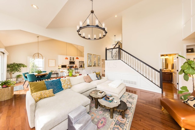5893 Dunheath Loop, Dublin, OH 43016 - living area featuring a chandelier, stairway, high vaulted ceiling, and wood-type flooring