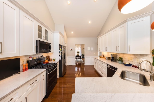 5893 Dunheath Loop, Dublin, OH 43016 - kitchen featuring range with gas stovetop, dishwasher, stainless steel fridge, vaulted ceiling, and white cabinetry