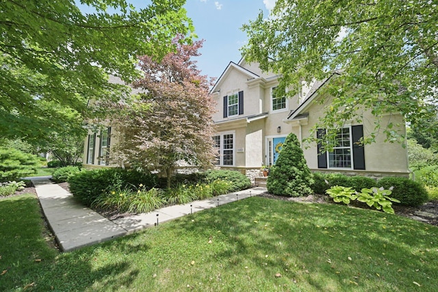 5893 Dunheath Loop, Dublin, OH 43016 - traditional-style house with stucco siding, a front yard, and stone siding