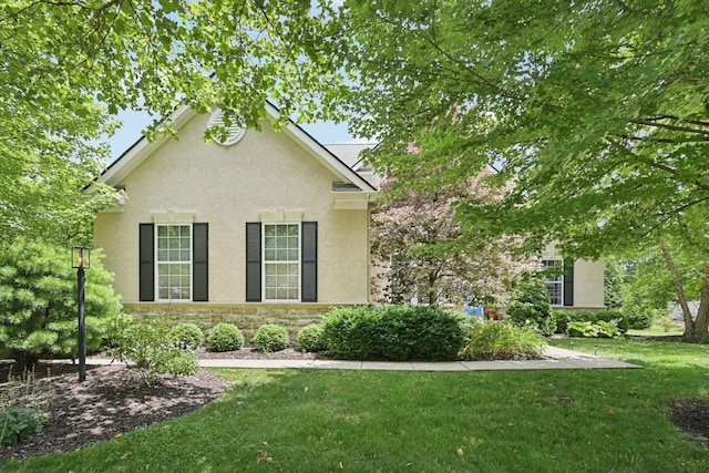 5893 Dunheath Loop, Dublin, OH 43016 - view of front of home with stucco siding, a front lawn, and stone siding
