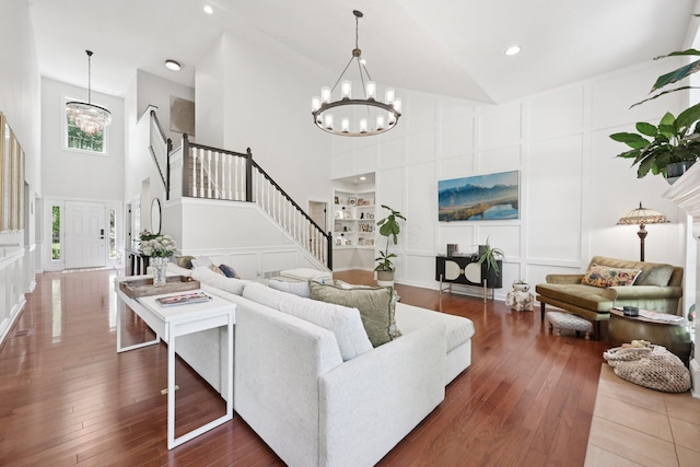 5893 Dunheath Loop, Dublin, OH 43016 - living room featuring a decorative wall, a chandelier, high vaulted ceiling, stairway, and dark wood finished floors