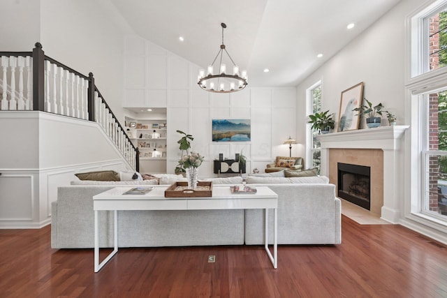 5893 Dunheath Loop, Dublin, OH 43016 - living room featuring high vaulted ceiling, a chandelier, dark wood-style floors, a tile fireplace, and stairway