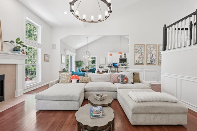 5893 Dunheath Loop, Dublin, OH 43016 - living area featuring a chandelier, plenty of natural light, high vaulted ceiling, wood finished floors, and a tile fireplace