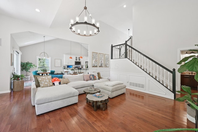 5893 Dunheath Loop, Dublin, OH 43016 - living room featuring a chandelier, stairway, wood finished floors, and high vaulted ceiling