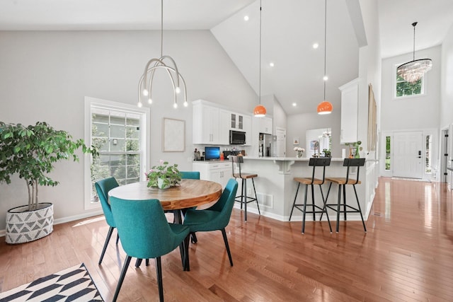 5893 Dunheath Loop, Dublin, OH 43016 - dining space featuring high vaulted ceiling, light wood-style floors, and a chandelier