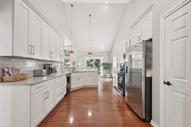 5893 Dunheath Loop, Dublin, OH 43016 - kitchen with stainless steel appliances, a peninsula, light countertops, white cabinetry, and backsplash