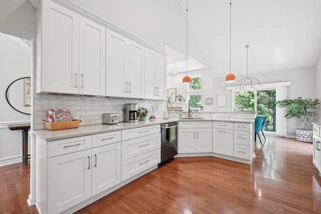 5893 Dunheath Loop, Dublin, OH 43016 - kitchen with stainless steel dishwasher, a peninsula, white cabinets, tasteful backsplash, and light wood-style flooring