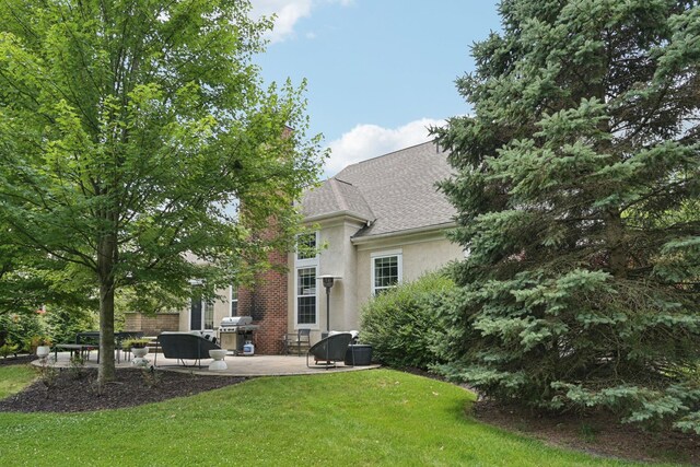 5893 Dunheath Loop, Dublin, OH 43016 - back of property with stucco siding, a patio, a yard, and a shingled roof