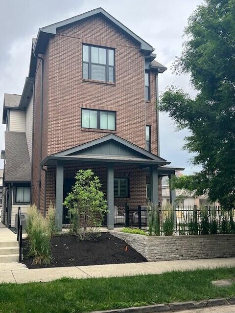 1301 Highland St, Columbus, OH 43201 - view of front of home featuring brick siding and a porch