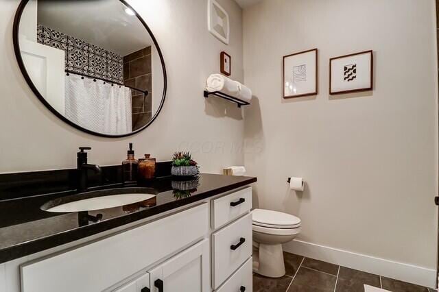 1301 Highland St, Columbus, OH 43201 - full bath with vanity, toilet, tile patterned flooring, baseboards, and a shower with shower curtain