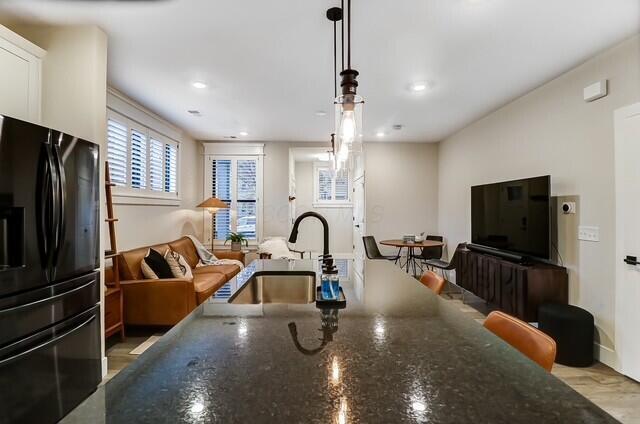 1301 Highland St, Columbus, OH 43201 - kitchen featuring freestanding refrigerator, a sink, open floor plan, white cabinetry, and dark stone countertops