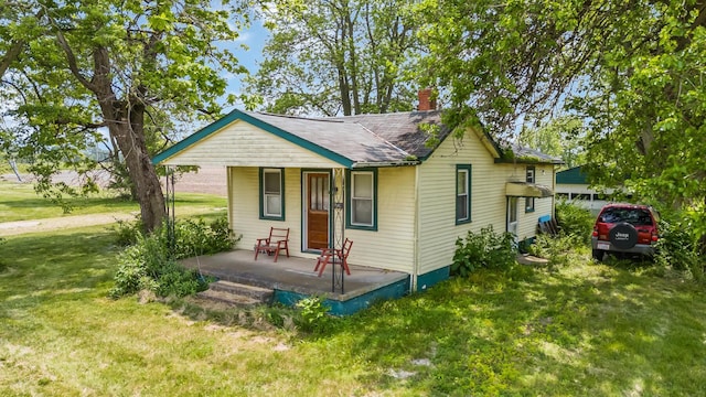 7365 Hayden Run Rd, Hilliard, OH 43026 - bungalow-style home featuring a porch, a chimney, and a front yard