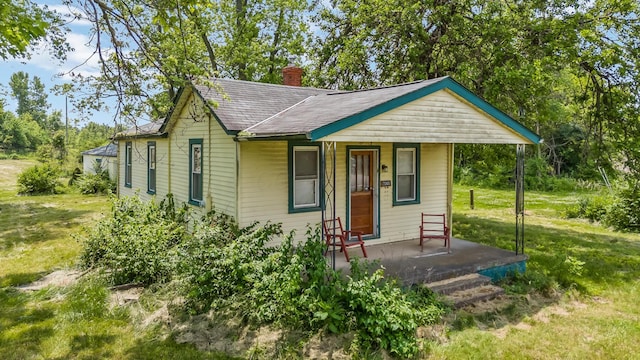 7365 Hayden Run Rd, Hilliard, OH 43026 - bungalow-style house with covered porch, a chimney, roof with shingles, and a front yard