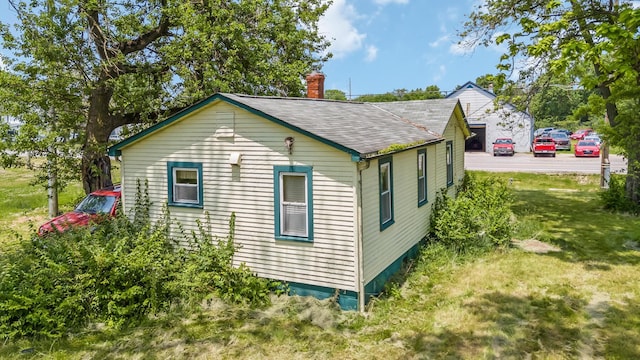7365 Hayden Run Rd, Hilliard, OH 43026 - view of side of home featuring a chimney, roof with shingles, and a yard
