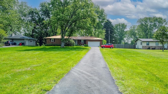 4019 Mink St SW, Pataskala, OH 43062 - ranch-style house with a garage, driveway, view of wooded area, and stone siding