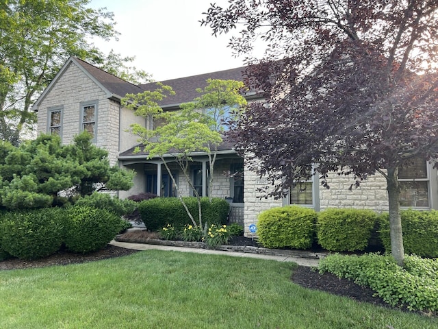 7524 Cumberland Cir NW, Canal Winchester, OH 43110 - view of front of house featuring stone siding, roof with shingles, and a front lawn