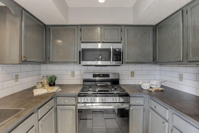2356 Gavinley Way, Columbus, OH 43220 - kitchen with appliances with stainless steel finishes, backsplash, dark countertops, and a textured ceiling