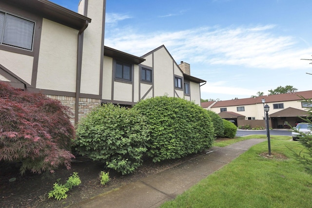 2356 Gavinley Way, Columbus, OH 43220 - view of side of property with a chimney, stucco siding, a lawn, and a residential view