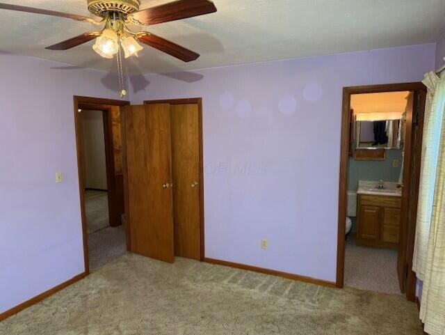 2377 E Howard Rd, Obetz, OH 43207 - unfurnished bedroom with carpet floors, a closet, ensuite bath, and ceiling fan