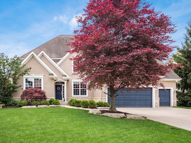 6165 Avocet Ct, Dublin, OH 43017 - view of front facade featuring stone siding, stucco siding, driveway, a front lawn, and roof with shingles