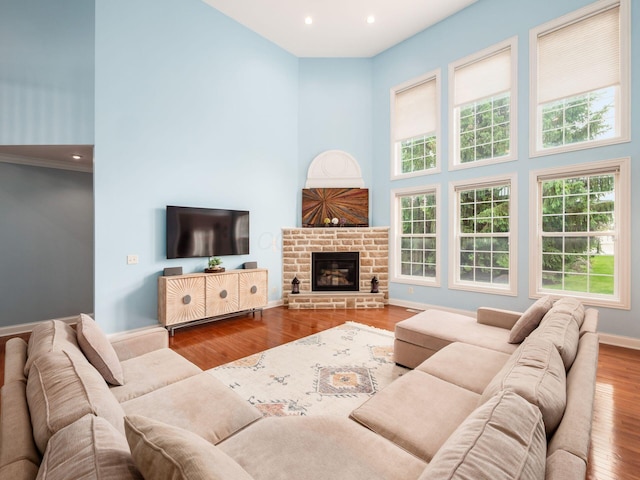 6165 Avocet Ct, Dublin, OH 43017 - living room featuring a towering ceiling, wood finished floors, a stone fireplace, and recessed lighting