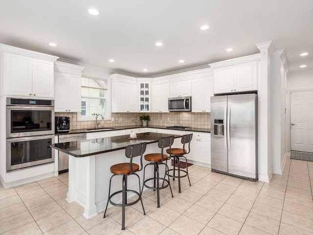 6165 Avocet Ct, Dublin, OH 43017 - kitchen with stainless steel appliances, a kitchen island, crown molding, dark countertops, and white cabinets