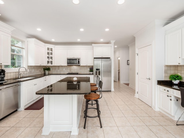 6165 Avocet Ct, Dublin, OH 43017 - kitchen featuring stainless steel appliances, backsplash, a kitchen breakfast bar, crown molding, and white cabinetry