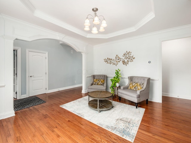 6165 Avocet Ct, Dublin, OH 43017 - sitting room featuring decorative columns, wood finished floors, ornamental molding, a chandelier, and a tray ceiling