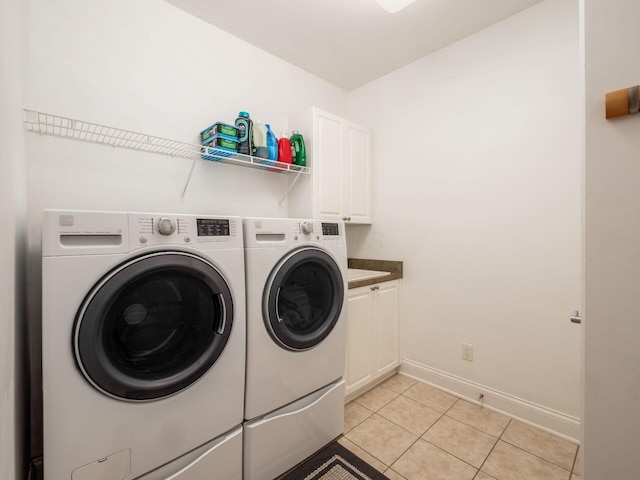 6165 Avocet Ct, Dublin, OH 43017 - laundry area with washer and clothes dryer, light tile patterned floors, and cabinet space