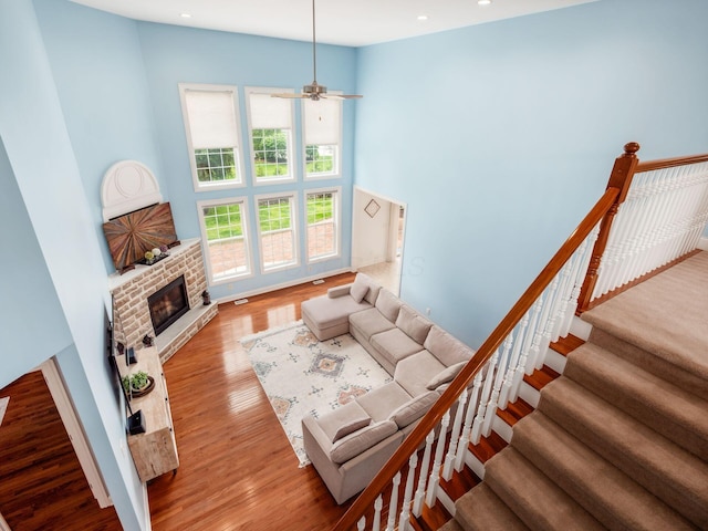 6165 Avocet Ct, Dublin, OH 43017 - living room with a towering ceiling, wood finished floors, a fireplace, a ceiling fan, and recessed lighting
