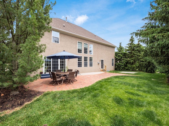 6165 Avocet Ct, Dublin, OH 43017 - rear view of house with stucco siding, a patio, and a yard