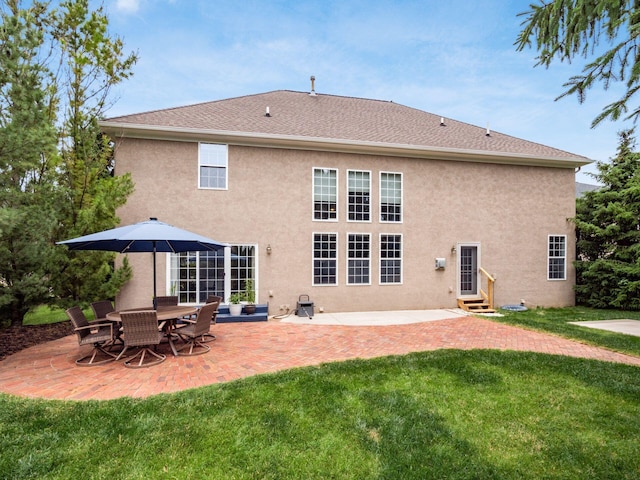6165 Avocet Ct, Dublin, OH 43017 - rear view of property featuring a yard, stucco siding, entry steps, and a patio