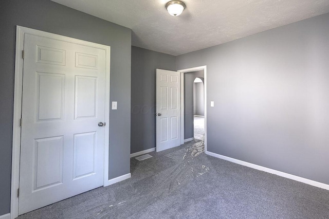 805 E Burgess St, Mount Vernon, OH 43050 - unfurnished bedroom with carpet flooring, arched walkways, and a textured ceiling