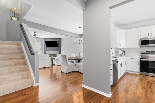6166 Albany Crest Ave, New Albany, OH 43054 - kitchen with stainless steel appliances, open floor plan, white cabinets, and wood finished floors